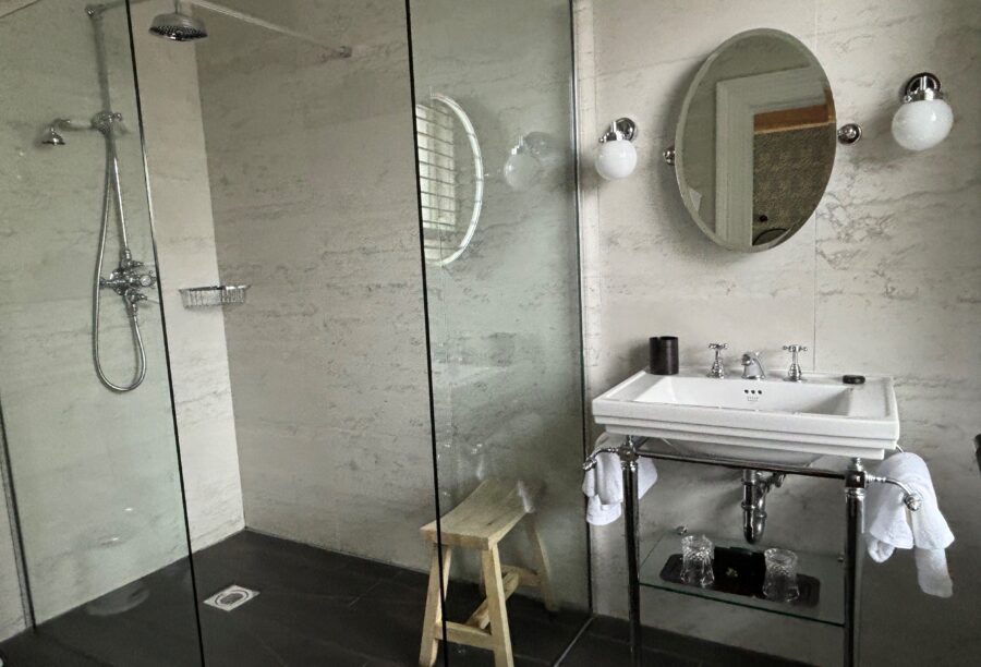 A close-up picture of the bathroom, with a shower and sink, in one of the bedrooms at Manor House Lindley.