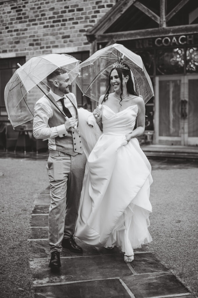 Bride and groom having picture outside with umbrellas at the Manor House Lindley