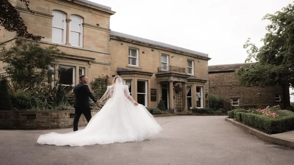 Bride and Groom walking towards the entrance at Manor House Lindley