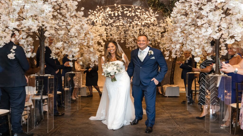 Bride and groom walking down the aisle after getting married inside the wedding venue at Manor House.