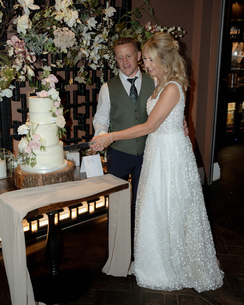 Groom Aaron and Bride Sam cutting wedding cake at Manor House Lindley