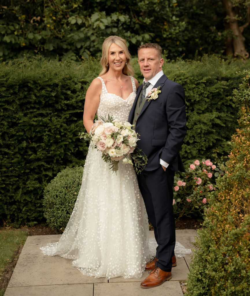 Groom Aaron and Bride Sam having picture outside Manor House Lindley