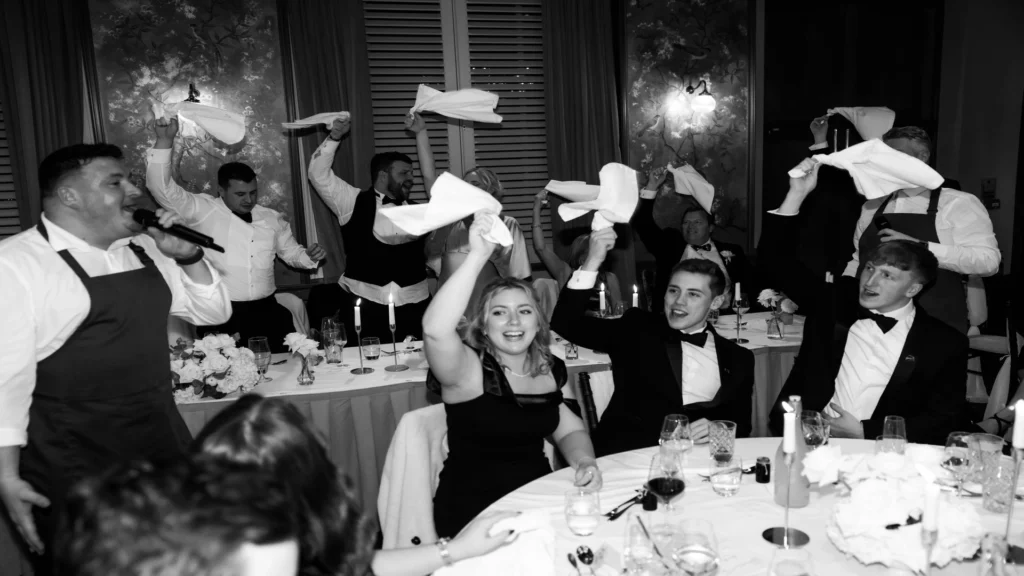 Black and white photo of wedding celebrations inside the wedding venue at Manor House Lindley