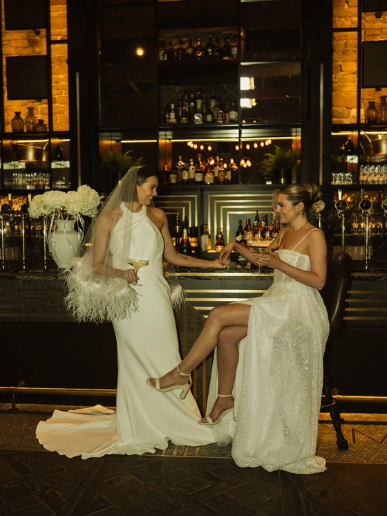 Bride at the bar with a glass of fizz at Manor House