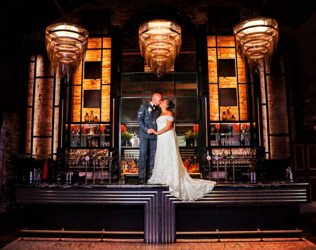 Bride and Groom kissing on the bar at Manor House Lindley