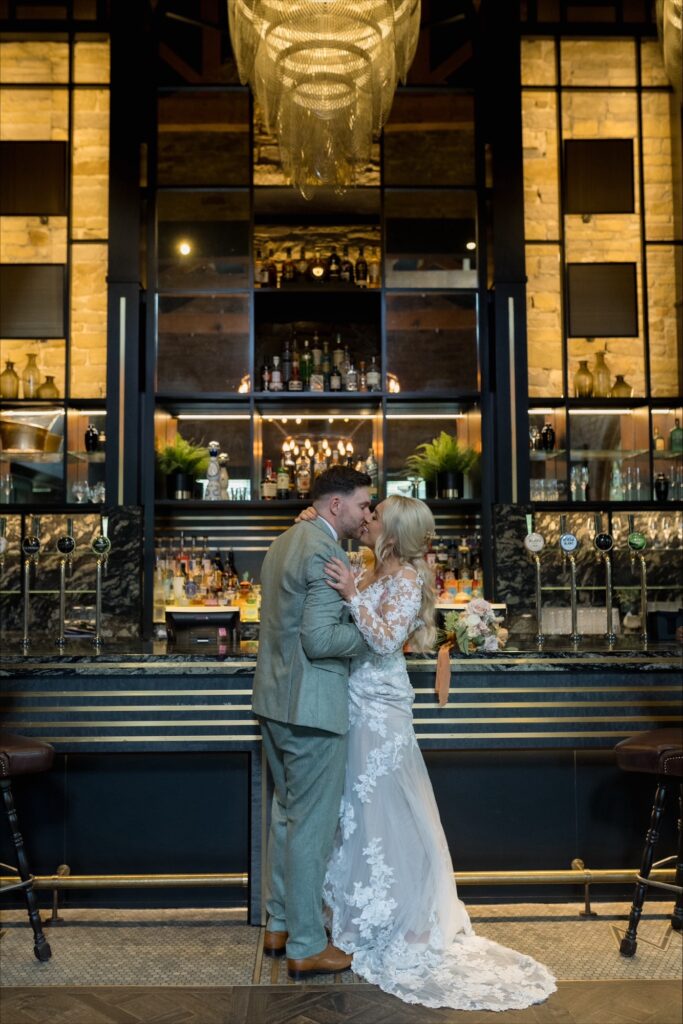 Bride and groom kissing at the bar inside Manor House Lindley