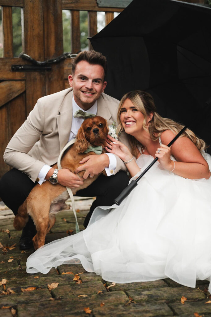 Picture of bride and groom outside in the grounds at Manor House Lindley with dog