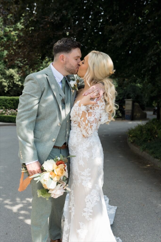 Bride and groom kissing outside the grounds of Manor House Lindley