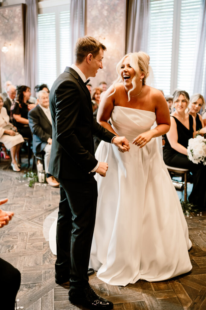 Bride Cara and Groom Shaun kissing on the aisle inside the wedding at Manor House Lindley