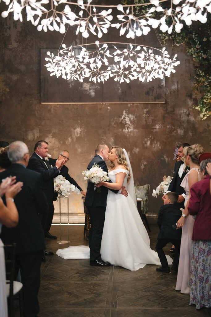 Bride Libby and groom kissing on the aisle after getting married