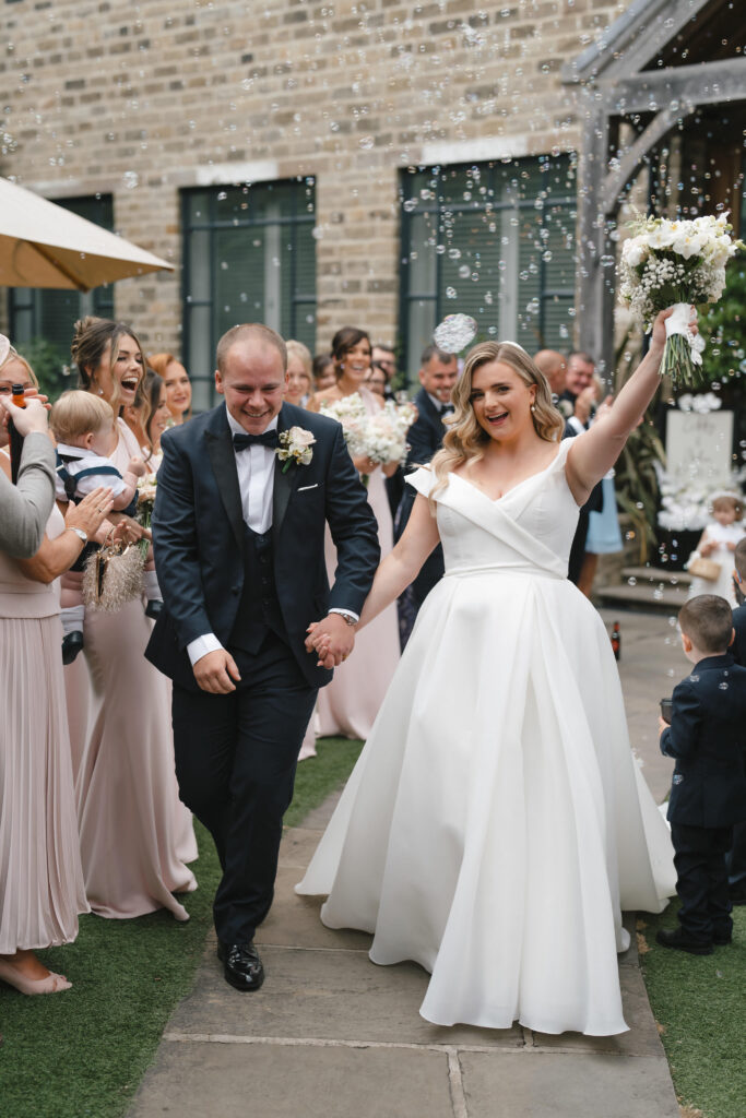 Bride, Libby and groom, walking down the pathway, celebrating after getting married.