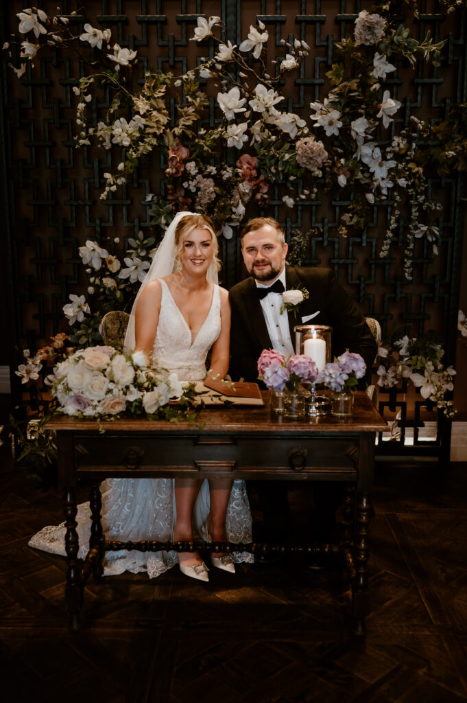 Bride Bonnie and Groom Luke sat together signing the marriage register